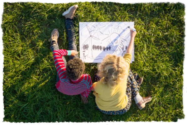 Enfants dessinant dans l'herbe